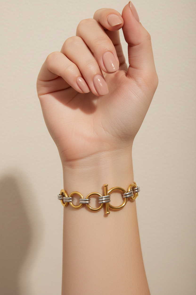 Brazalete de metal mixto oro y plata en mano